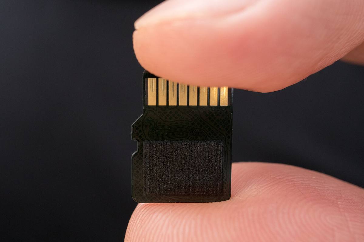 Paměťová karta microSD držená mezi dvěma prsty